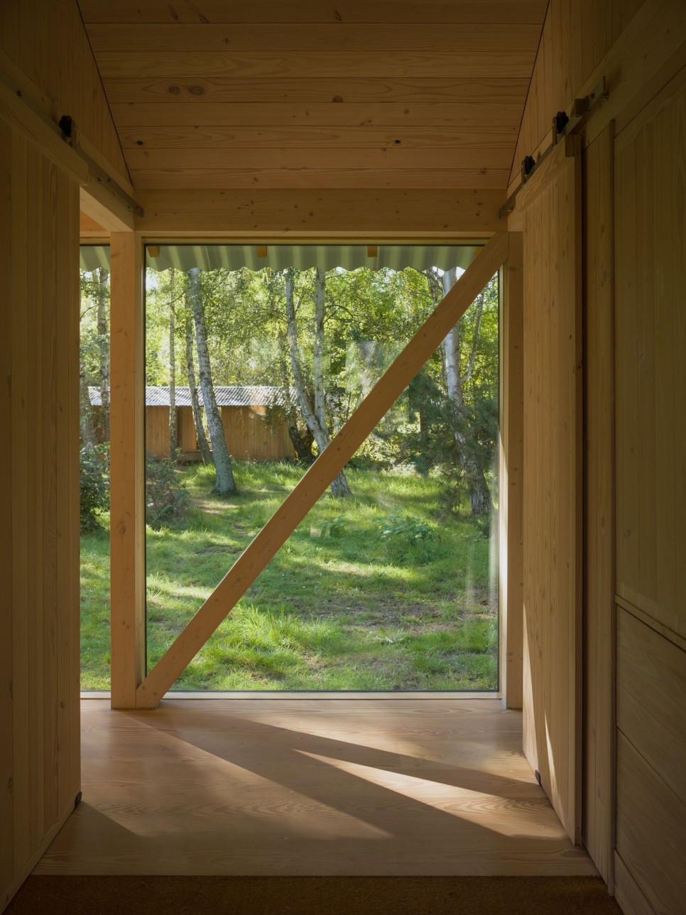 세로 패턴 숲속에 낮은 수평 구조로 지은 여름 별장, Vollerup House by Høyer Arkitektur